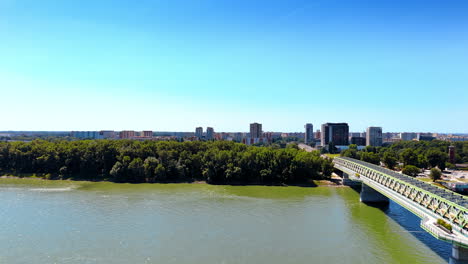 rise over the green waterscape of the danube river in bratislava, slovakia. footage near the structure of the old bridge.