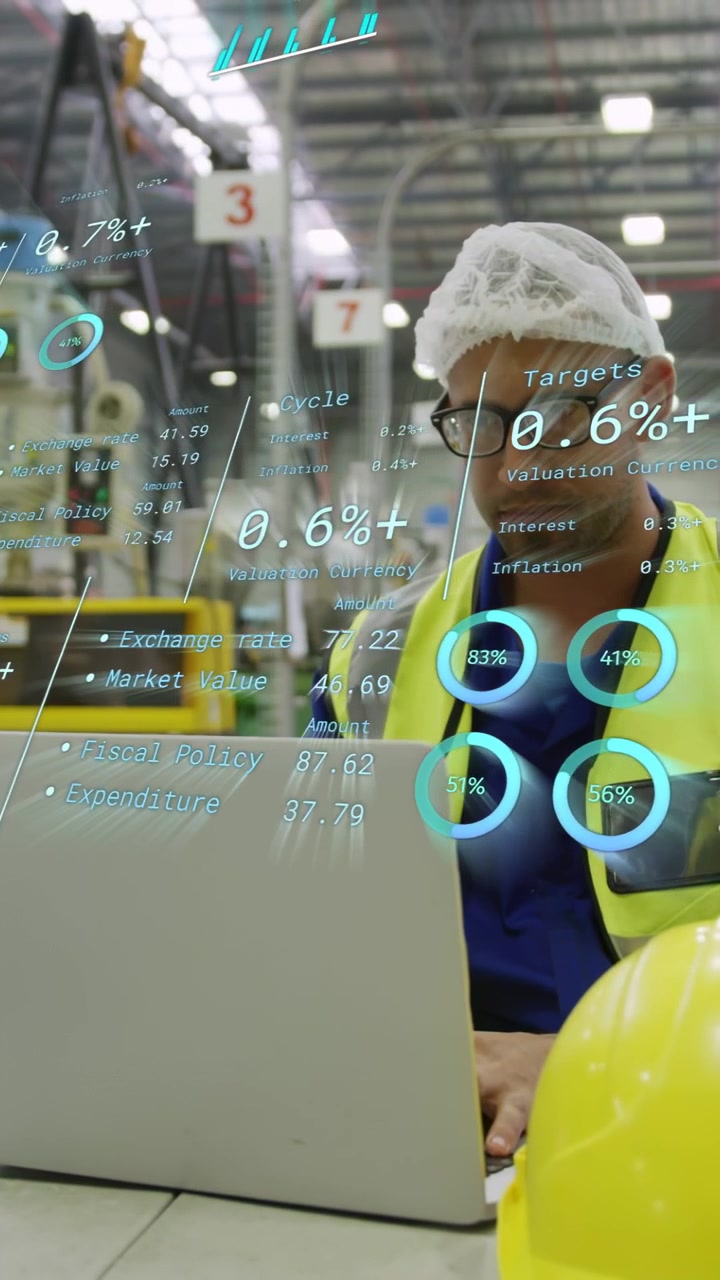 Vertikal video: Tekniker ved bærbar computer på fabrik tjekker målinger, mens AR-diagrammer vises, gul hat.