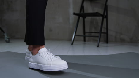 white leather sneakers on legs