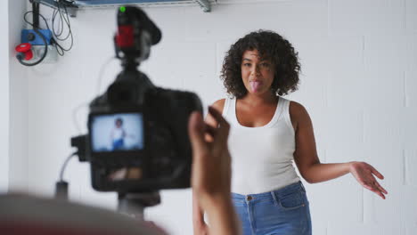 female videographer filming woman recording podcast in studio