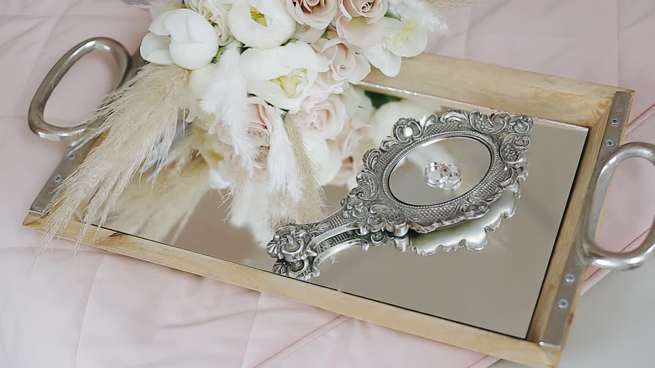 On the tray is a bouquet of flowers and a mirror with rings. Beautiful holiday items