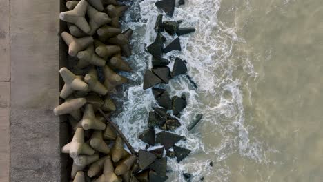 Vista-Aérea-Del-Muelle-De-Hormigón-Del-Puerto-De-Liepaja,-Día-De-La-Costa-Del-Mar-Báltico,-Grandes-Olas-Salpicando,-Tiro-De-Drones-De-Ojo-De-Pájaro-En-Cámara-Lenta-Avanzando