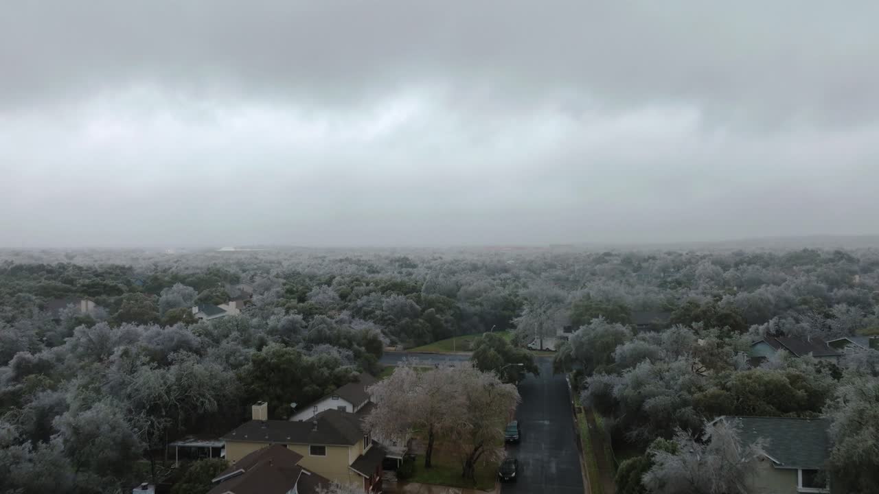 추운 겨울 동안 오스틴 텍사스 교외 지역의 얼어붙은 얼음 나무, 공중 드론이 남쪽 오스틴 주택 위로 올라갑니다.