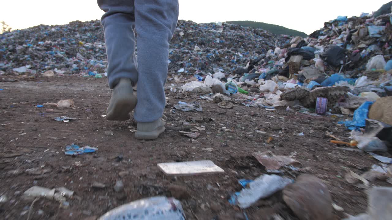Person walking through a large landfill