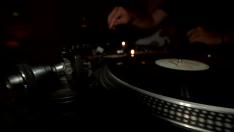dj hand gira el disco, la cámara se mueve hacia la izquierda
