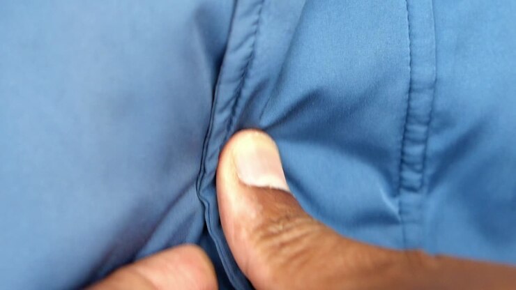 Primo piano di una camicia blu con una mano
