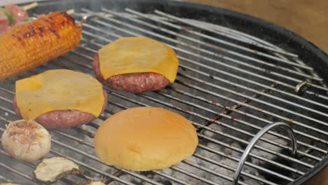 cooking meat cutlets with cheese for humburgers, kebab and vegetables on grill close-up. making chicken,beef or pork kebab. barbecue for friends and family. cafe and restaurant food.