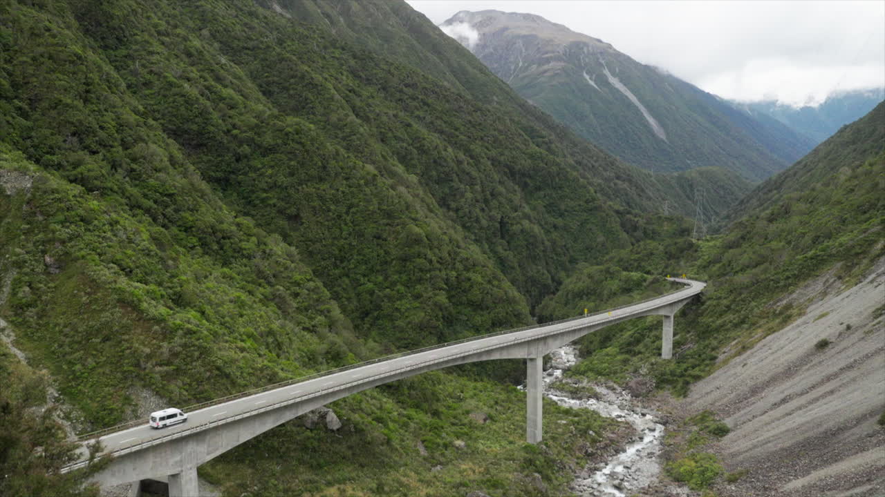 미니 버스가 뉴질랜드의 아서스 패스에서 오티라 다리 (otira viaduct bridge) 를 가로지르고 있다.