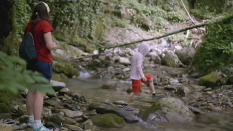 family hiking in a forest creek