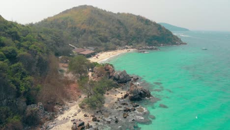 Cabaña-De-Playa-De-Arena-Con-Techo-Plano-Marrón-Cerca-Del-Océano-Azul