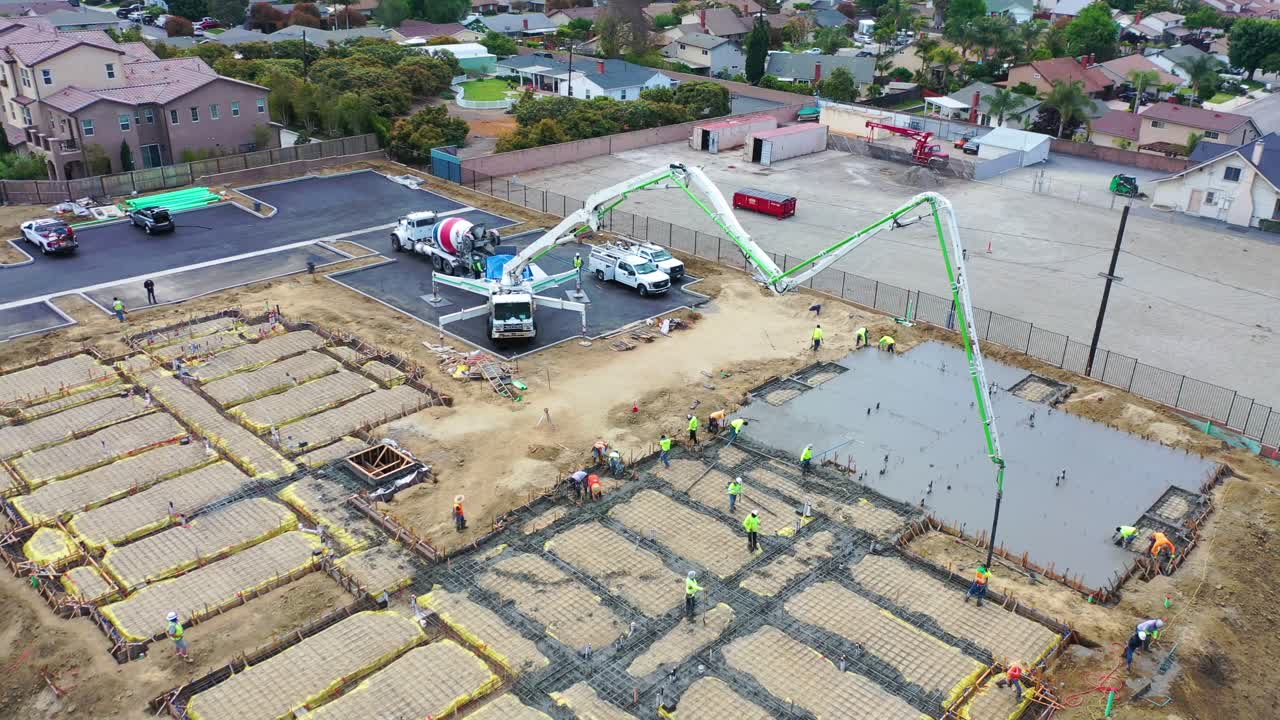 antena notable sobre el sitio de construcción con grúa gigante y trabajadores que vierten cimientos de hormigón en ventura california 5