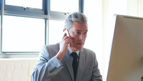 businessman using his computer and smartphone