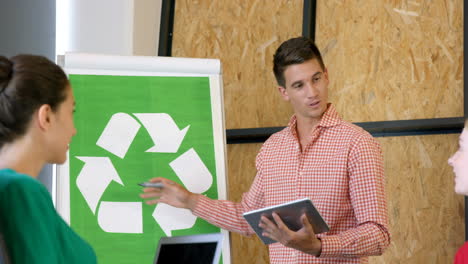 Kollegen-Diskutieren-Mit-Recycling-Zeichen-Auf-Der-Weißen-Tafel