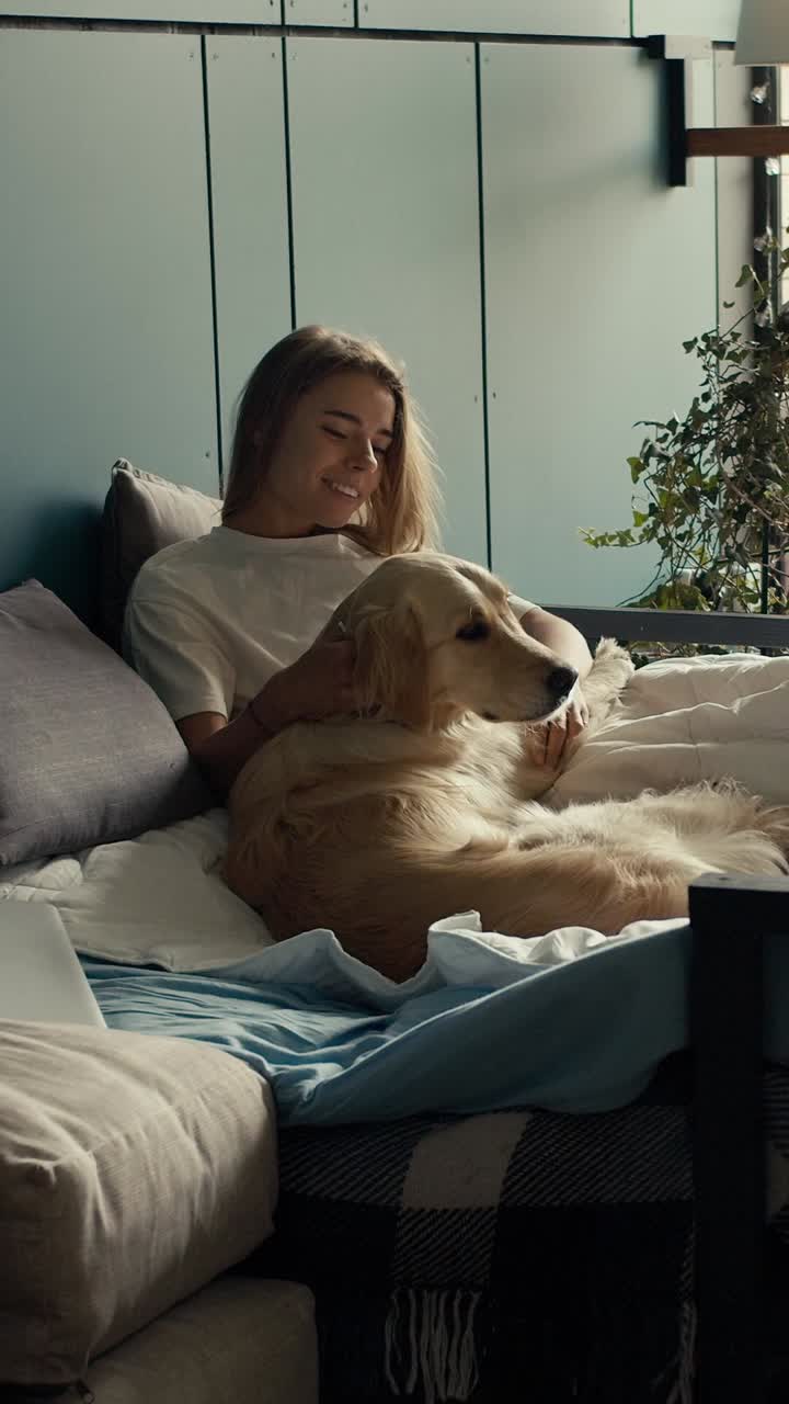Woman relaxing with her dog in bed