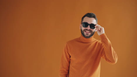 man in orange turtleneck sweater and sunglasses