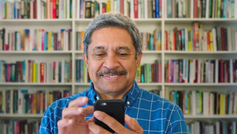 Older-male-bookstore-owner-using-a-phone-inside