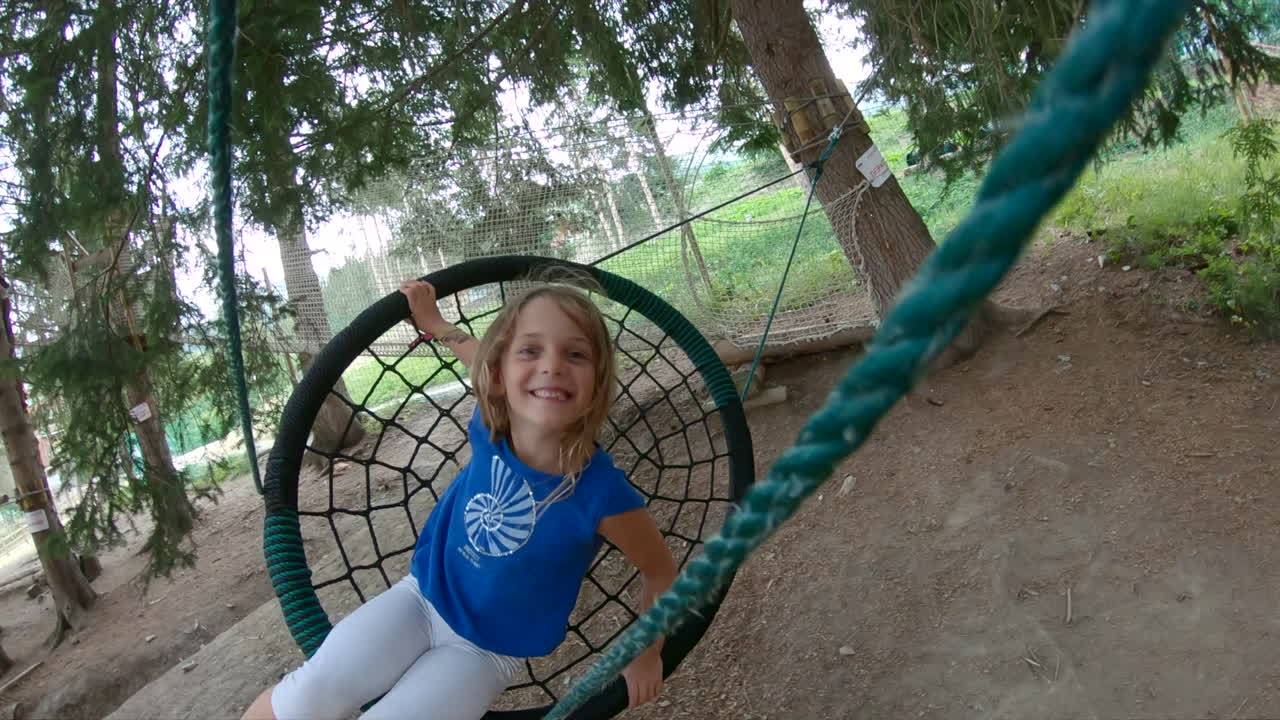 Giovane ragazza felice su un'altalena a rete ad amaca.