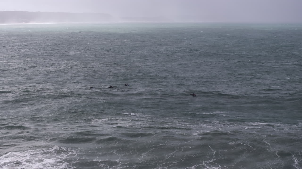Jet ski operators drifting near giant Nazaré turbulence. Portugal, Europe, big wave professional tow-in surfing destination