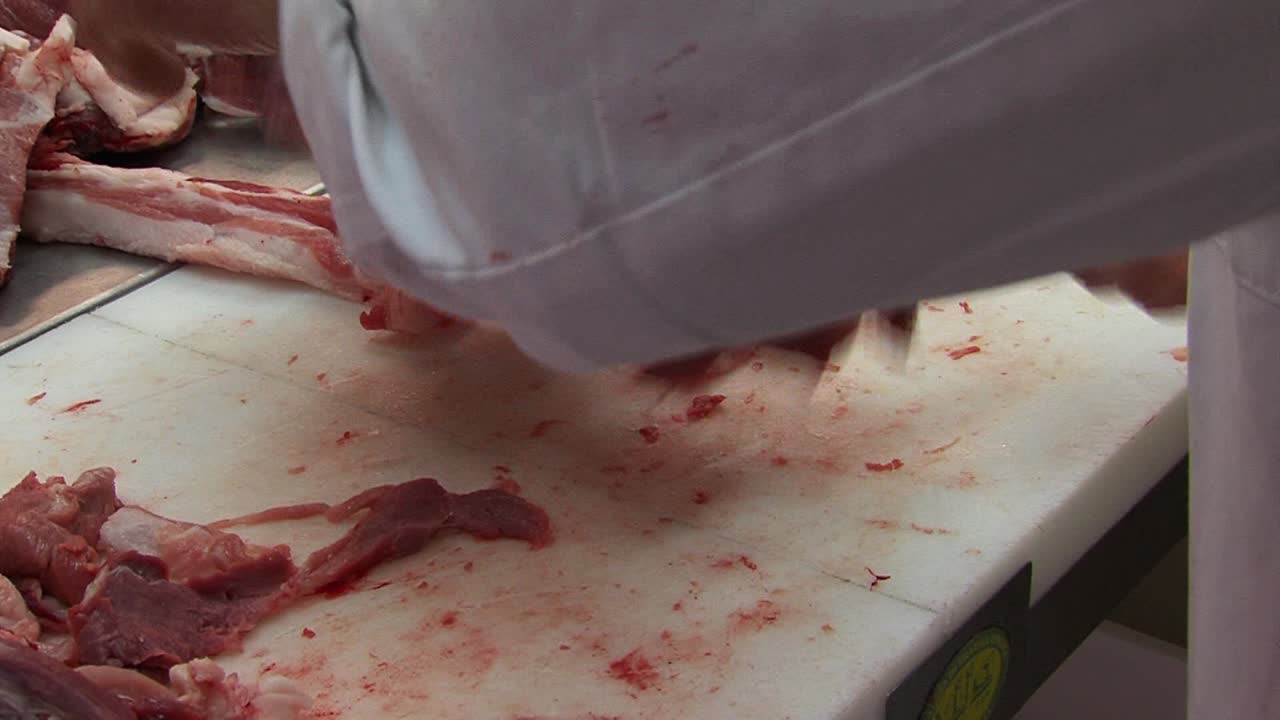 숙련된 정육점은 신선한 생 돼지 고기에서 피부를 자르고, 근접 촬영 평면도