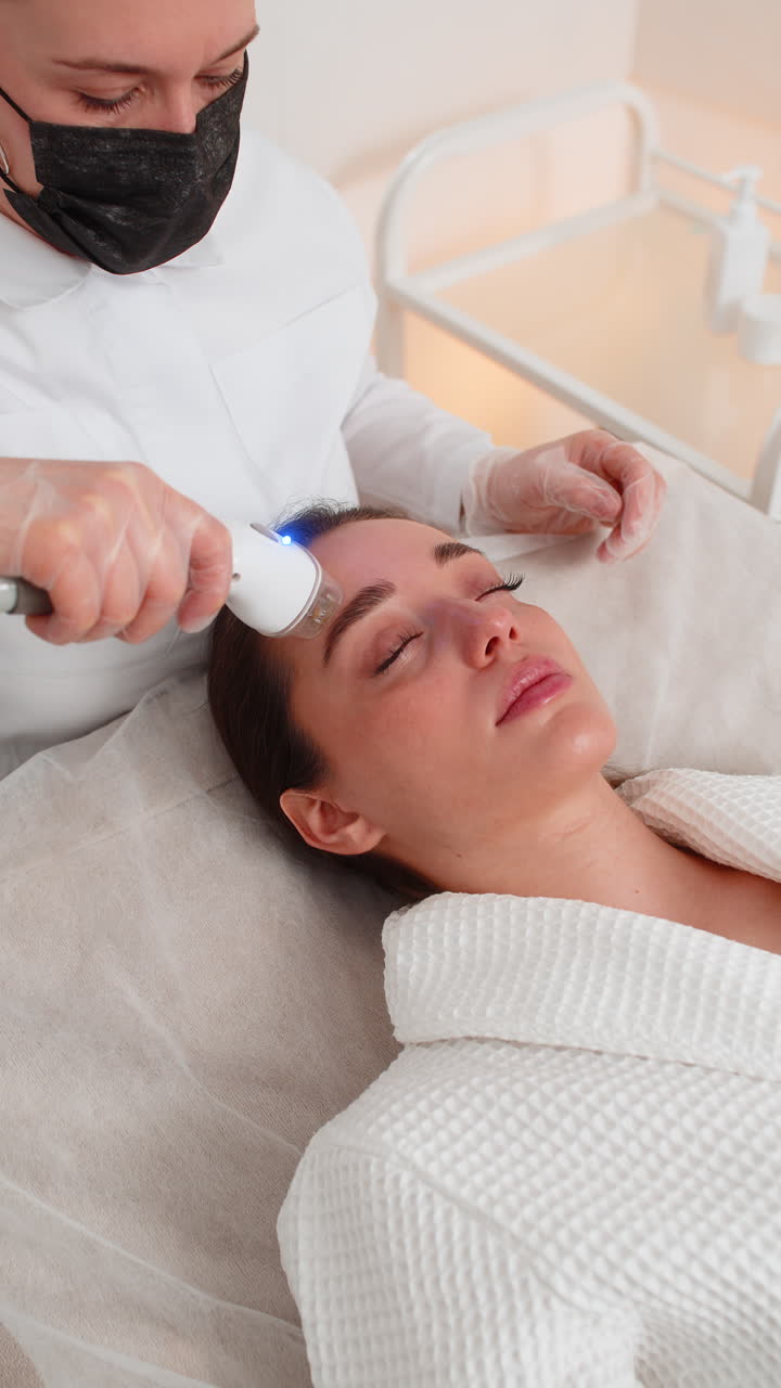 Rf face lifting procedure for young woman in cosmetology clinic by professional cosmetologist doctor