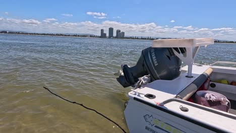 small motorboat in a bay with cityscape view