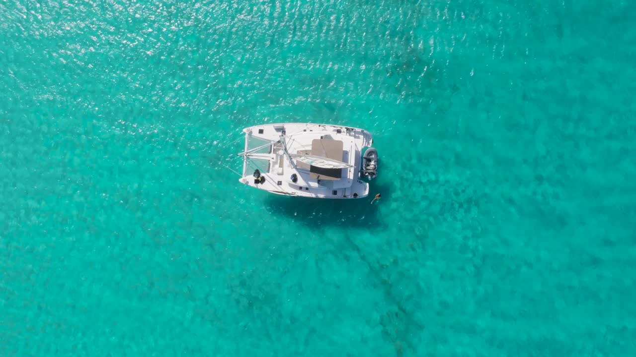 vista aérea de arriba hacia abajo de drones de las bahamas isla desierta con velero y océano azul cristalino