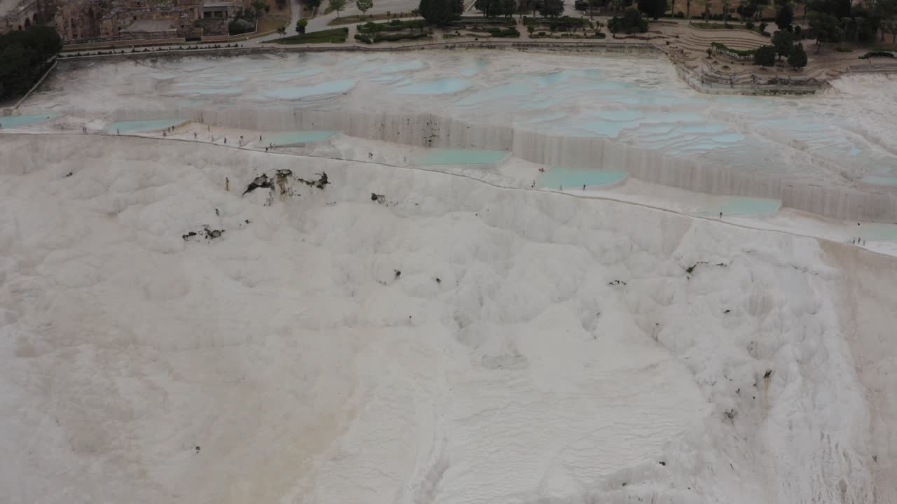 Drone flying away from Pammukale White Termal Pool Natural Hot Spring terrace Turkey