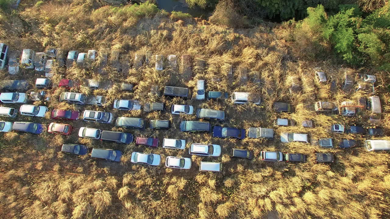Vista aerea di auto abbandonate nella zona di esclusione di Fukushima, invase da erba alta.