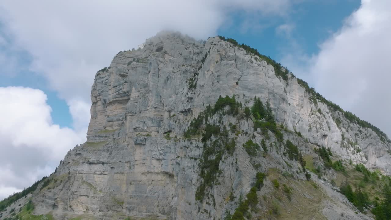 Ripresa circolare della vetta rocciosa del Monte Granier, avvolta da nuvole
