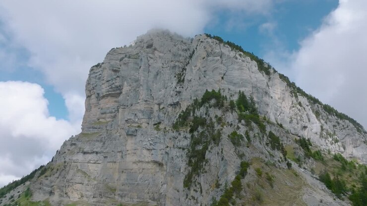Ripresa circolare della vetta rocciosa del Monte Granier, avvolta da nuvole