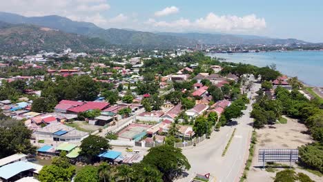 aerial drone of capital city dili in remote tropical island timor leste, south east asia, lowering towards road and traffic