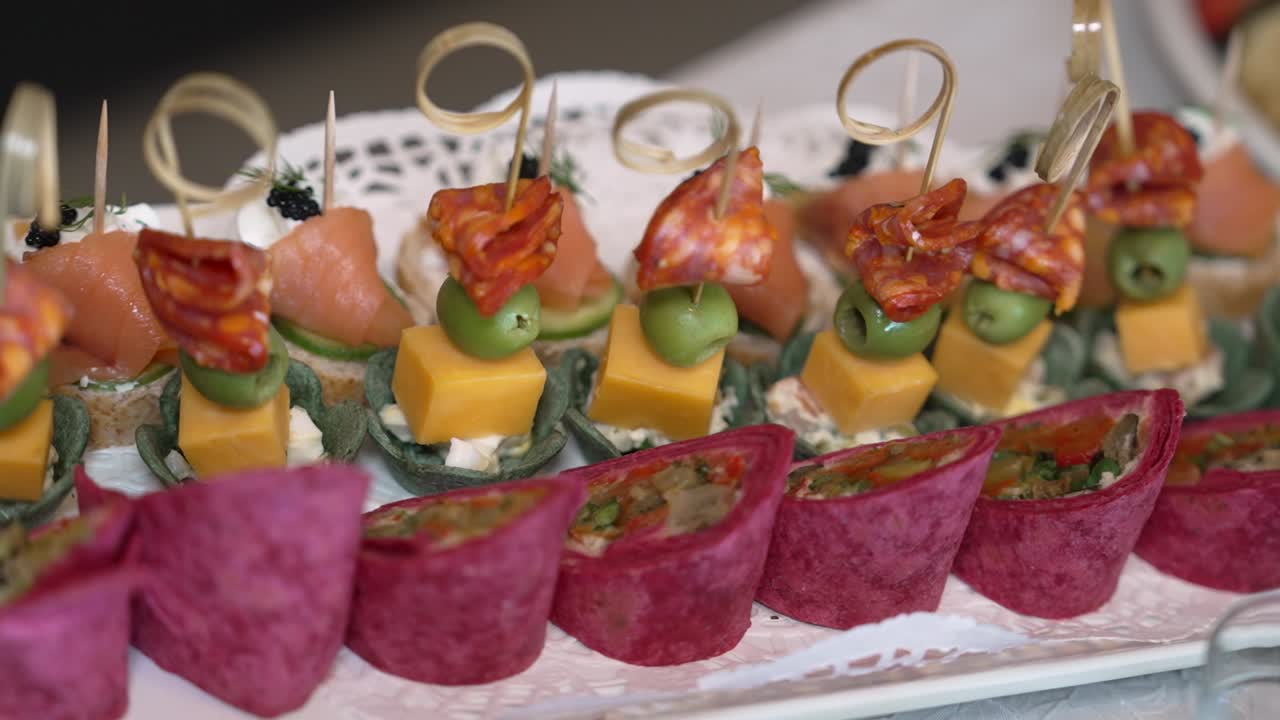 Los invitados disfrutan de deliciosos aperitivos servidos en una fuente decorativa durante una reunión vespertina. Diversos sabores y texturas crean un surtido atractivo para que todos lo prueben.