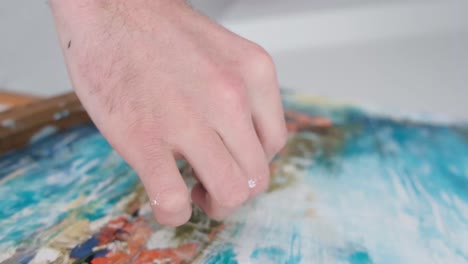 close-up of an artist creating an abstract painting with a palette knife