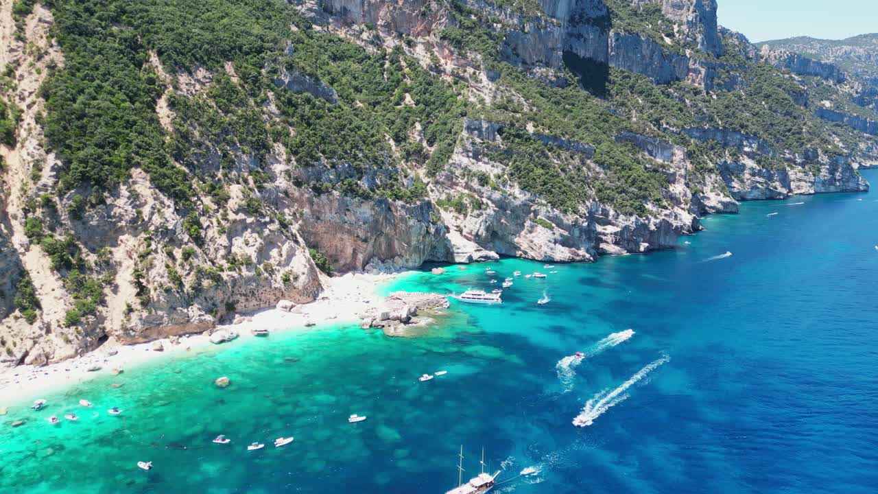 Bådture og turister ved Cala Mariolu Strand, Baunei Kysten, Sardinien, Italien - Luftfoto 4K