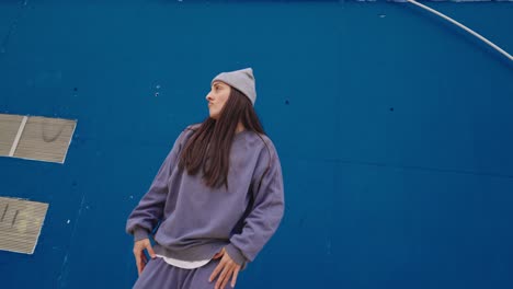 woman dancing in front of a blue wall