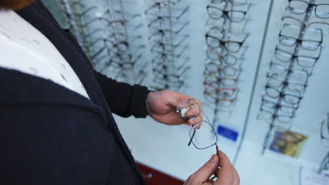 man choosing eyeglasses at store. handsome man patient looking and picking frame