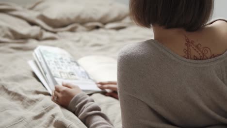 mujer relajándose en la cama, leyendo un libro