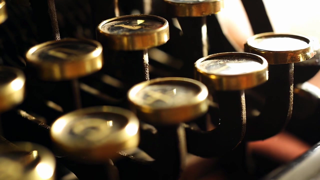 Finger Pressing Golden Keys of a Retro Typewriter