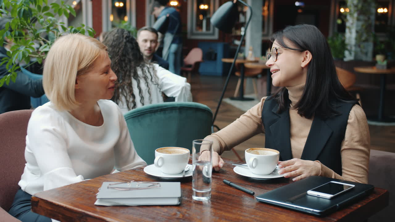 mujeres de negocios se reúnen en un café.
