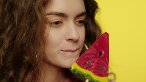 young woman licking candy in studio