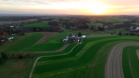 aerial of contour farming and crop rotation theme with american farmland at sunset