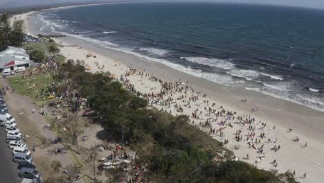 4k-Wide-drone-shot-of-surfers-protesting-against-norwegian-oil-company,-Equinor,-at-Byron-Bay,-New-South-Wales,-Australia---2019