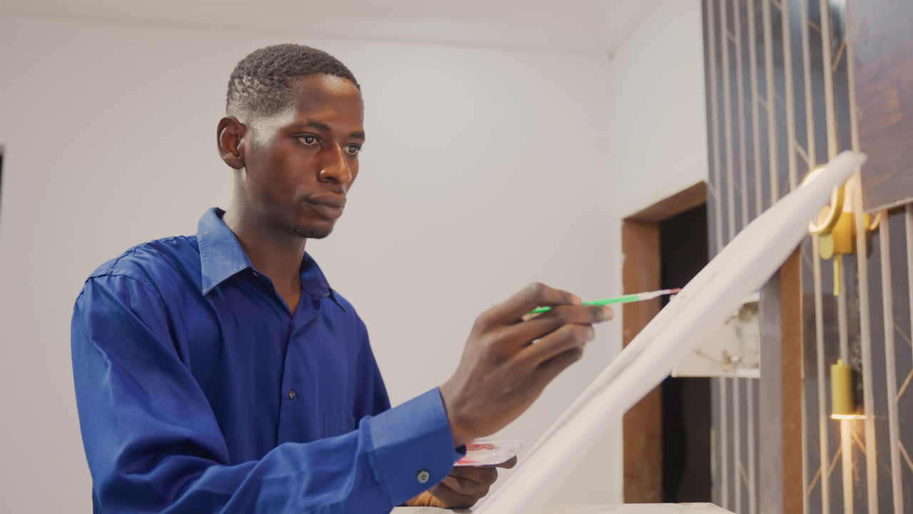Black man painting detailed strokes on canvas, closeup brushwork, intense concentration, blue shirt, modern interior, steady hand, ambient ring light, professional craft and precision