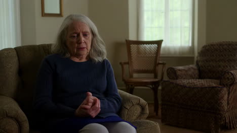 elderly woman sitting alone and contemplative