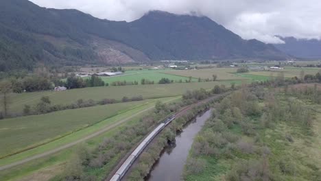 CN-passenger-train-moves-along-fields-of-Agassiz,-BC-Canada