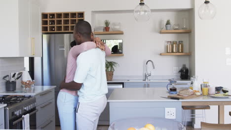 Una-Pareja-Afroamericana-Comparte-Un-Cálido-Abrazo-Y-Un-Abrazo-En-La-Cocina.