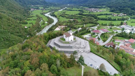 tomada aérea de un dron en órbita alrededor de una iglesia en eslovenia con montañas en el fondo, 4k uhd