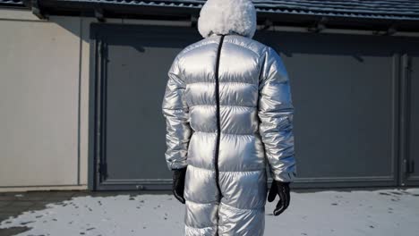 woman in a silver puffer jumpsuit in winter