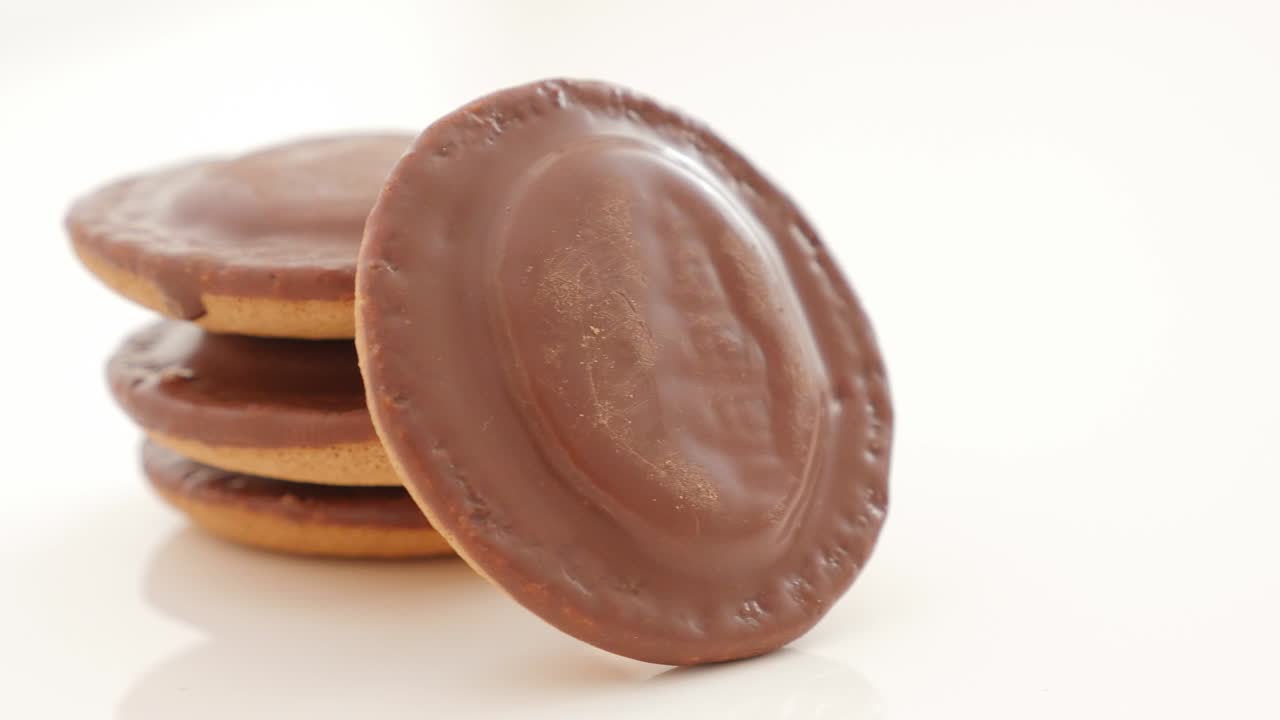 galletas de naranja esmaltadas con chocolate sobre un fondo blanco panorámica lenta 4k