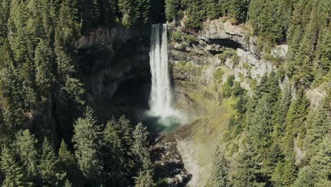 Powerful-Waterfall-Pouring-Over-Ledge-Amongst-Trees-In-British-Columbia,-Canada